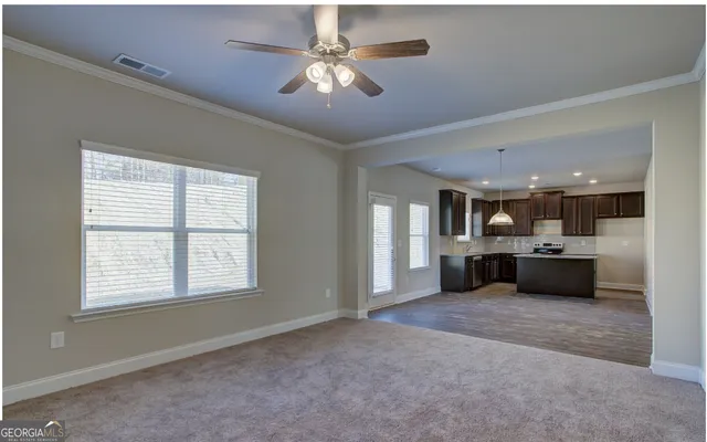 a view of a livingroom with a ceiling fan and window