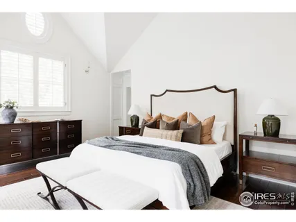 a bedroom with a bed and a dresser with mirror