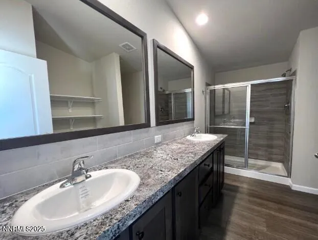 a bathroom with a granite countertop sink a mirror and shower