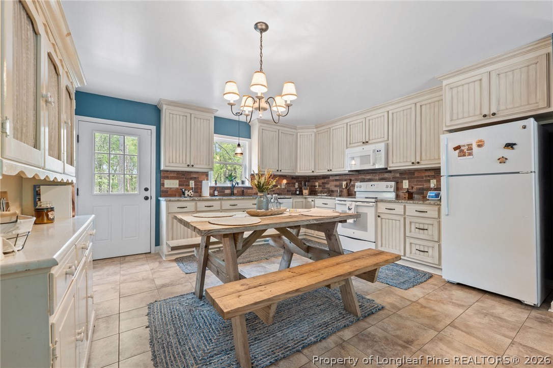 186 Lewis Brown Road Bennett, NC 27208 - Photo 12 of 48 a kitchen with a refrigerator a stove a sink and dishwasher with wooden floor