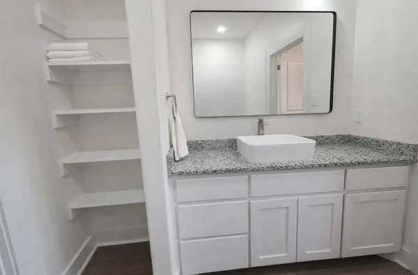 a bathroom with a granite countertop double vanity sink and mirror