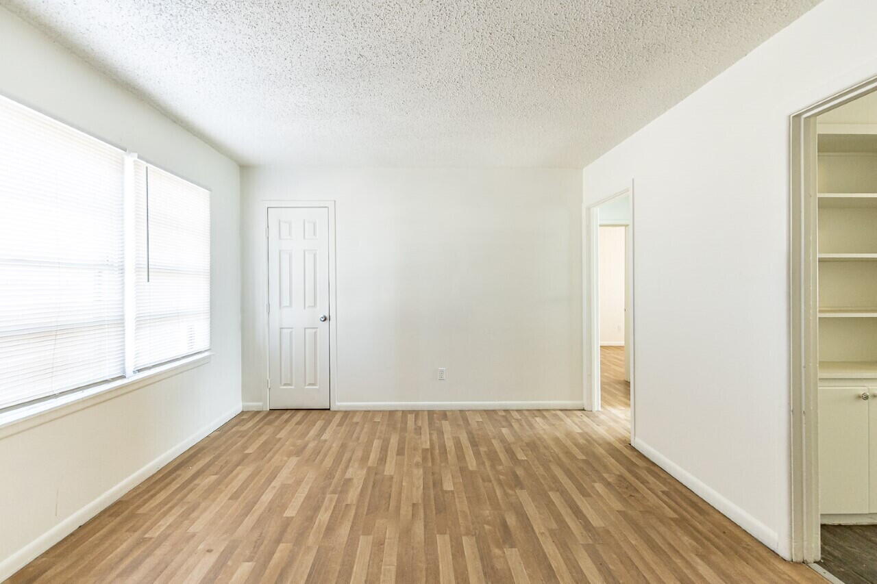 4823 35th Street Lubbock, TX 79414 - Photo 3 of 8 an empty room with wooden floor and windows