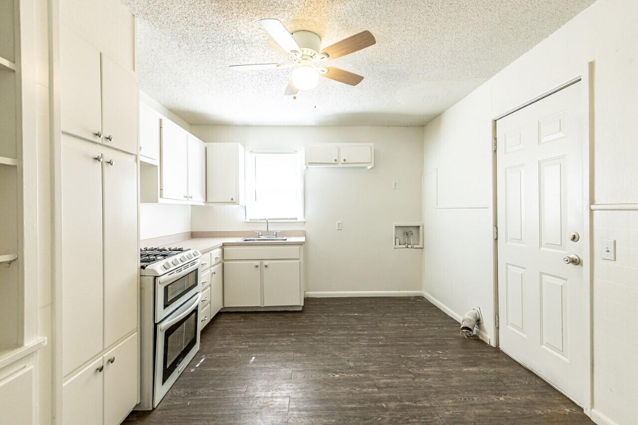 4823 35th Street Lubbock, TX 79414 - Photo 4 of 8 a kitchen with a sink stove and refrigerator