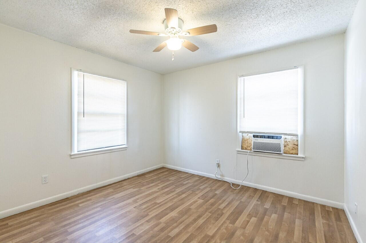 4823 35th Street Lubbock, TX 79414 - Photo 7 of 8 an empty room with a window and wooden floor