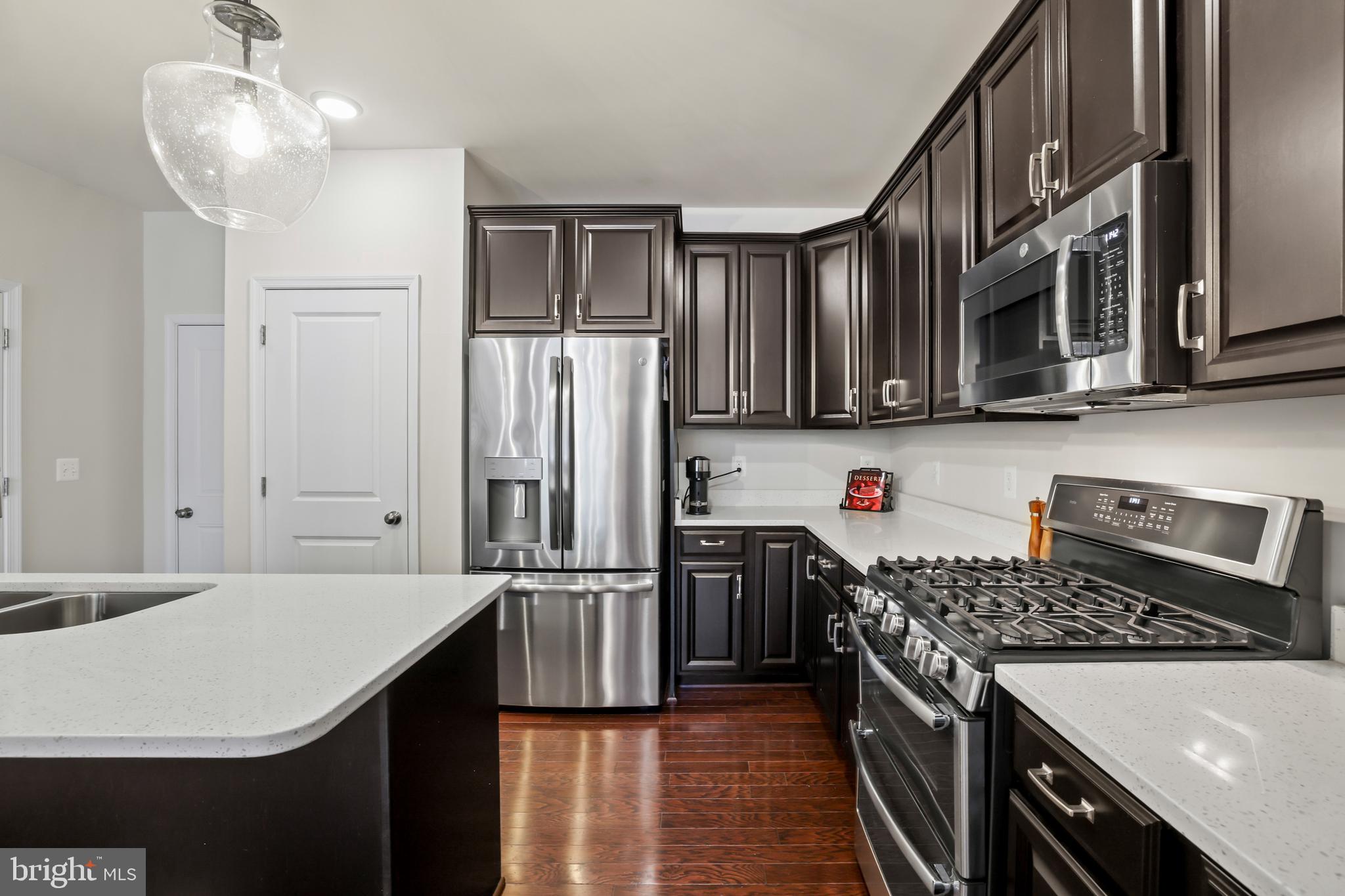 1102 Ribbon Limestone Terrace Southeast Leesburg, VA 20175 - Photo 12 of 51 a kitchen with stainless steel appliances granite countertop a refrigerator a stove and a sink with cabinets