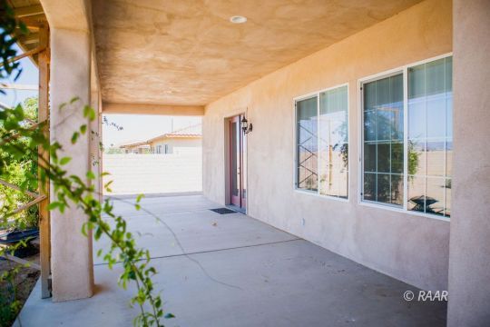 128 West Franklin Avenue Ridgecrest, CA 93555 - Photo 31 of 35 a view of an entryway with flower plants and wooden fence