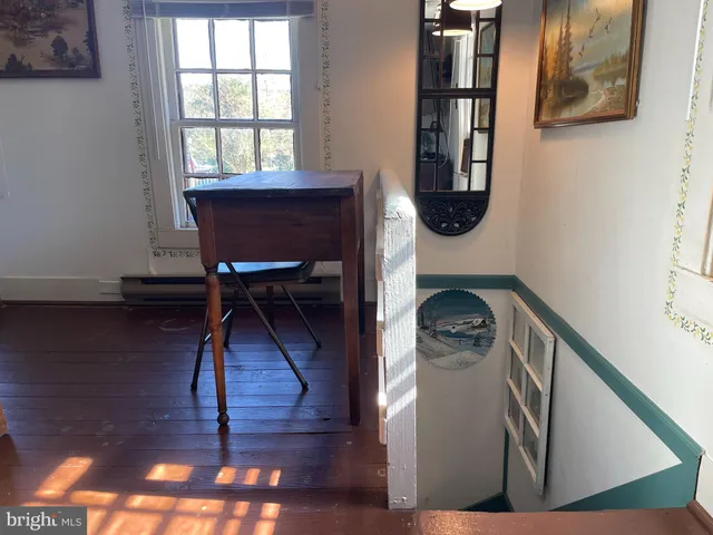 a view of entryway and hall with wooden floor
