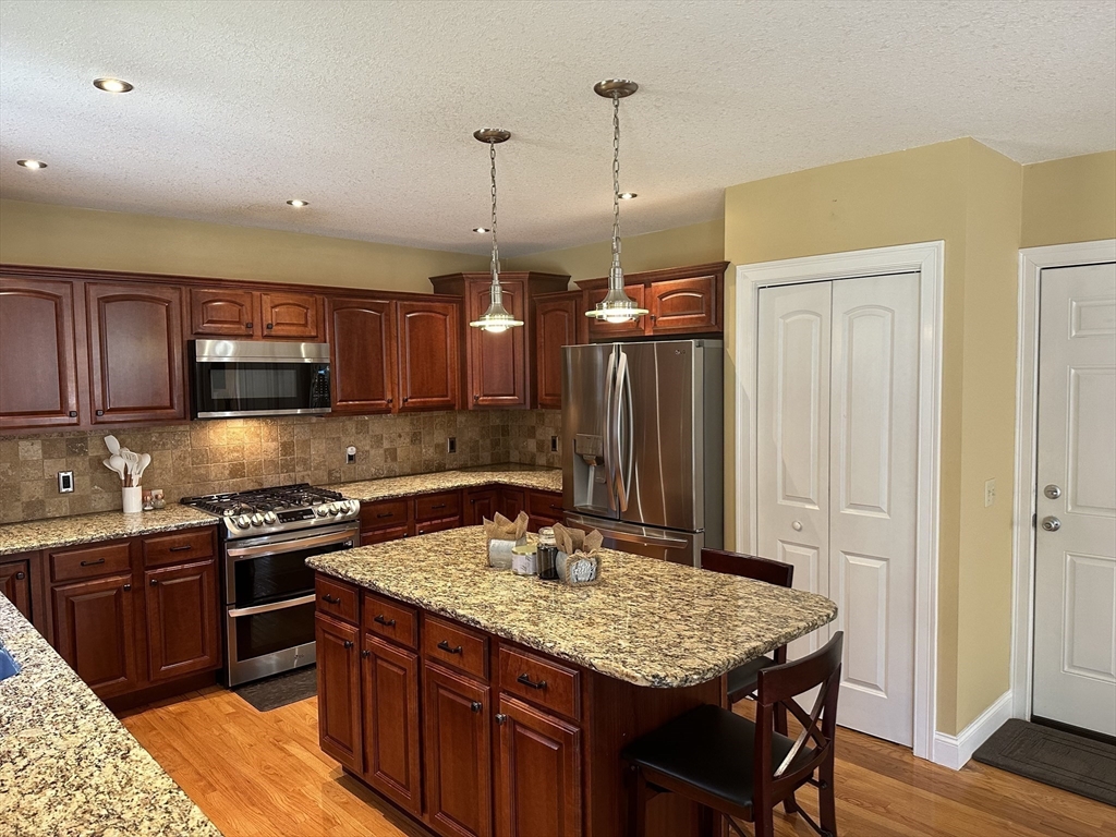 329 Forest Hills Road Springfield, MA 01128 - Photo 11 of 42 a kitchen with stainless steel appliances granite countertop a sink a stove and a wooden floors