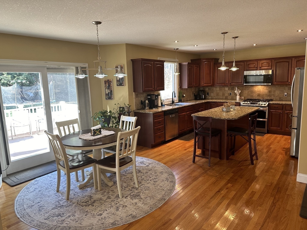 329 Forest Hills Road Springfield, MA 01128 - Photo 14 of 42 a dining room with a table chairs and a kitchen view