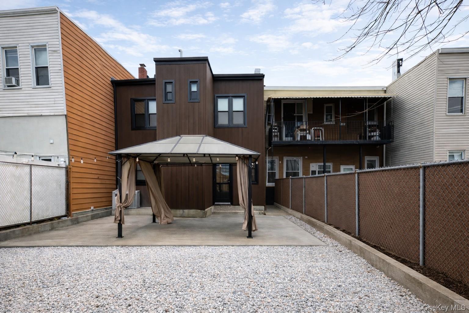 60-89 54th Street Queens, NY 11378 - Photo 4 of 22 Rear view of house with a gazebo and a patio area