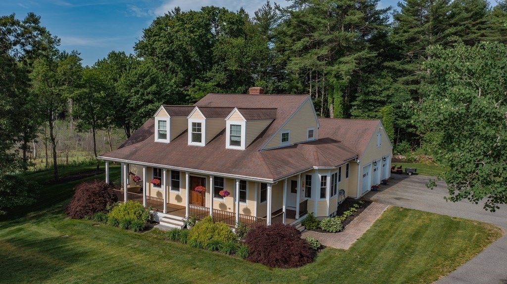 a aerial view of a house next to a big yard and large trees