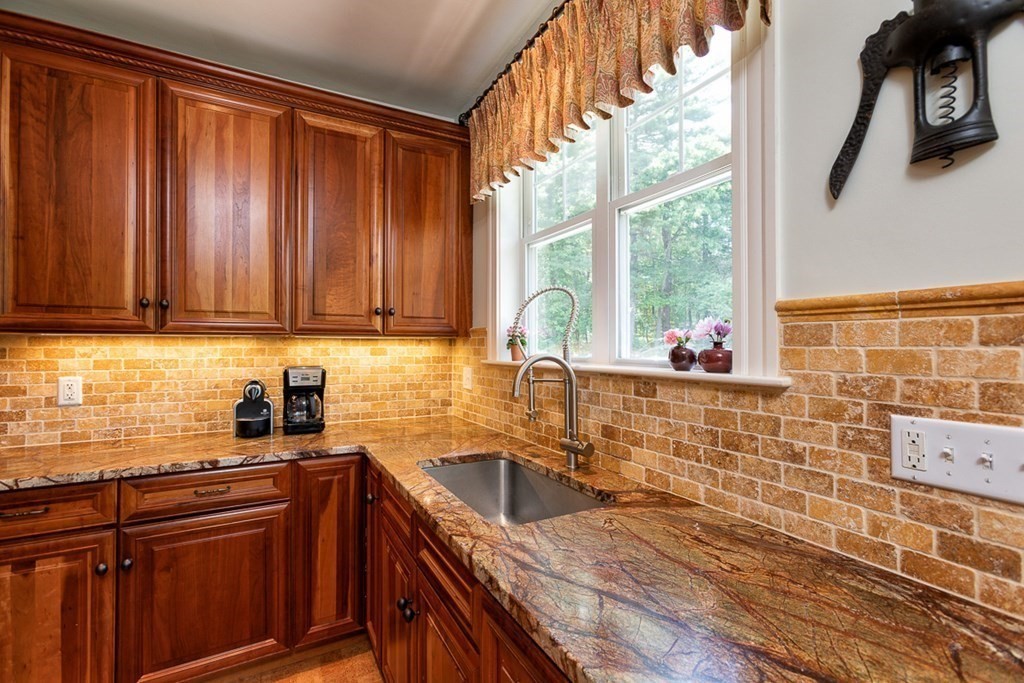 237 Newbury Road Rowley, MA 01969 - Photo 6 of 36 a kitchen with stainless steel appliances wooden cabinets a sink and a large window