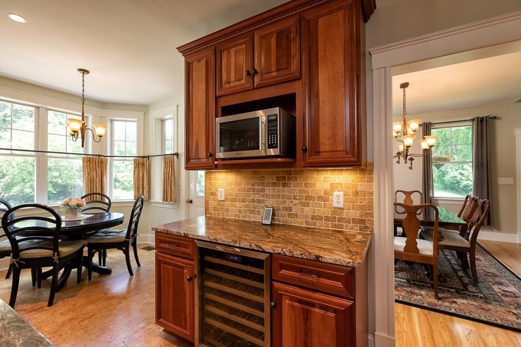 237 Newbury Road Rowley, MA 01969 - Photo 7 of 36 a kitchen with granite countertop a stove a sink a dining table and chairs
