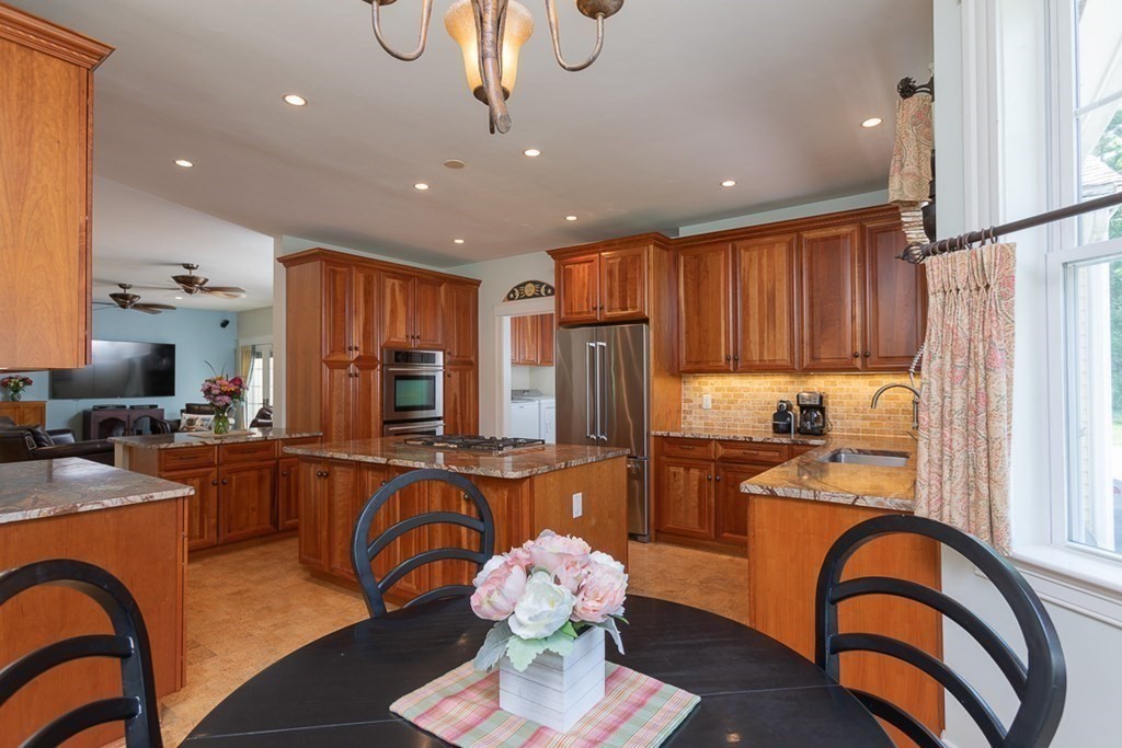 237 Newbury Road Rowley, MA 01969 - Photo 10 of 36 a kitchen with stainless steel appliances granite countertop a refrigerator a stove a sink dishwasher with a dining table and chairs