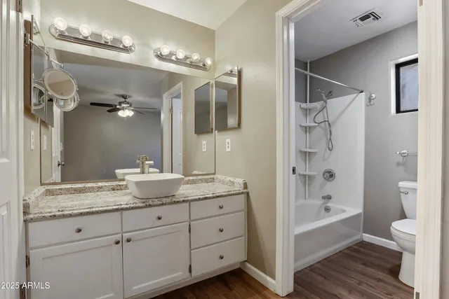 a bathroom with a granite countertop sink a large mirror a bathtub and shower
