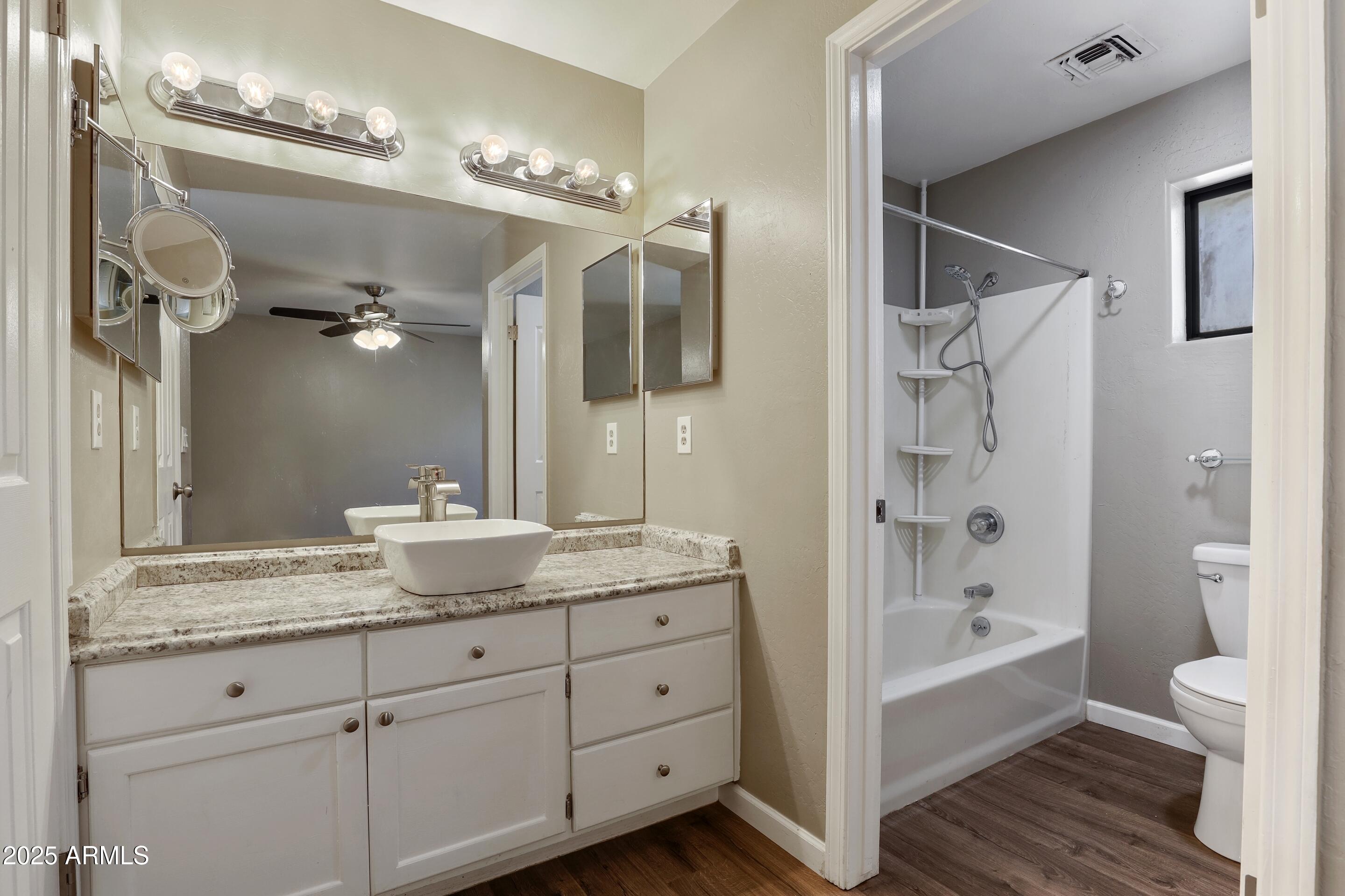 700 West Longhorn Road Payson, AZ 85541 - Photo 12 of 29 a bathroom with a granite countertop sink a large mirror a bathtub and shower