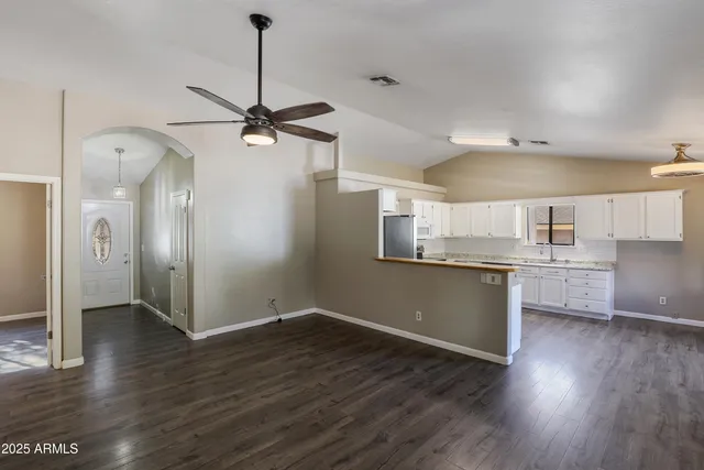 a kitchen with stainless steel appliances granite countertop a sink cabinets and wooden floor