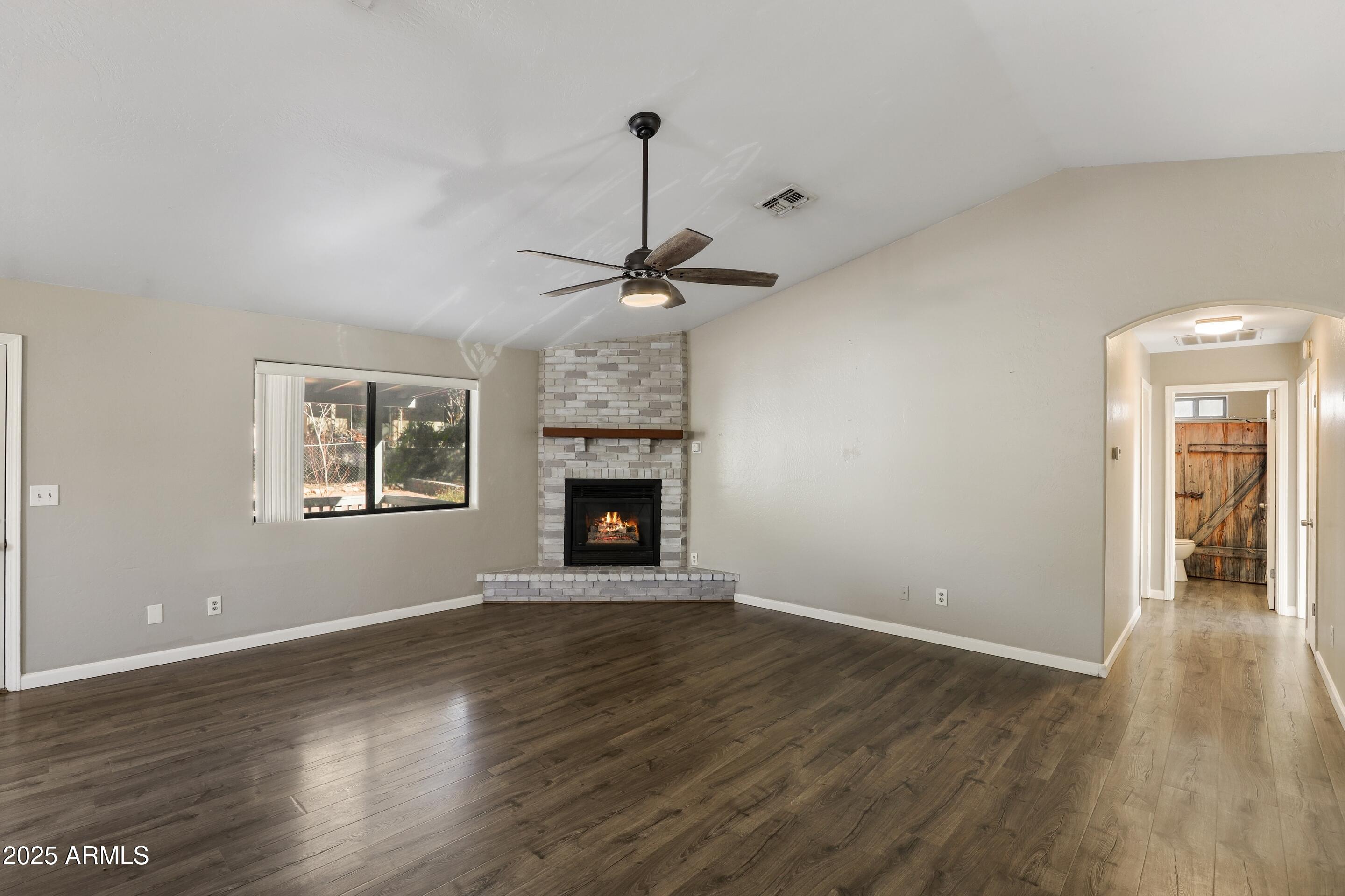 700 West Longhorn Road Payson, AZ 85541 - Photo 4 of 29 a view of an empty room with wooden floor fireplace and a window