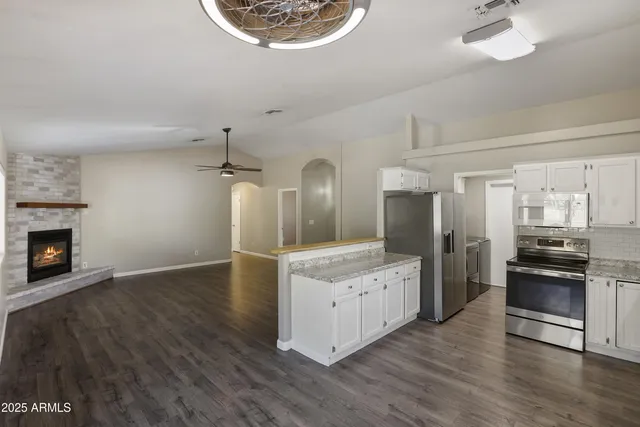 a large kitchen with stainless steel appliances granite countertop a stove and a refrigerator