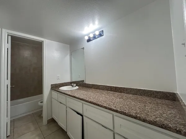 a bathroom with a granite countertop sink and vanity
