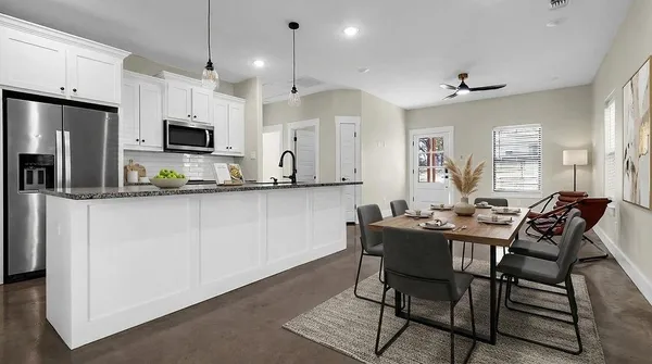 a kitchen with kitchen island granite countertop a table and chairs in it