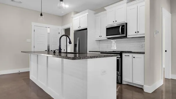 a kitchen with stainless steel appliances granite countertop a stove microwave and sink