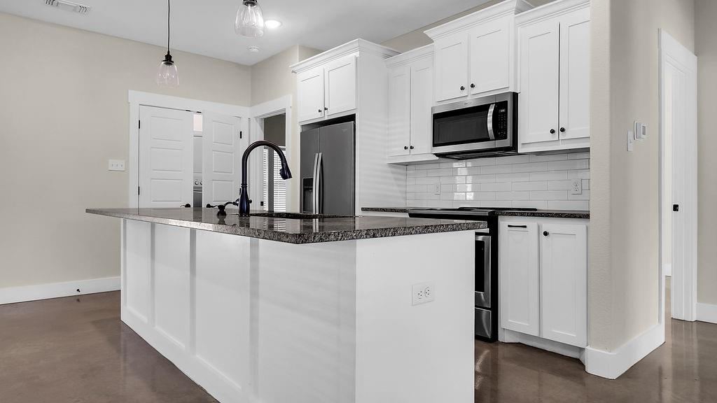 727 East Gandy Street Denison, TX 75021 - Photo 2 of 21 a kitchen with stainless steel appliances granite countertop a stove microwave and sink