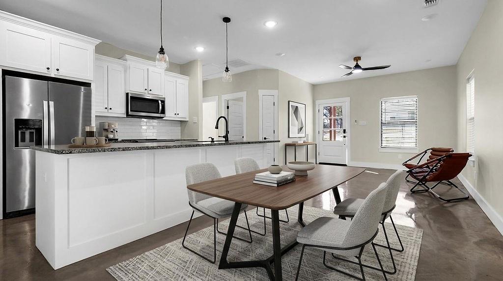 727 East Gandy Street Denison, TX 75021 - Photo 21 of 21 a kitchen with stainless steel appliances kitchen island granite countertop a dining table chairs and a refrigerator