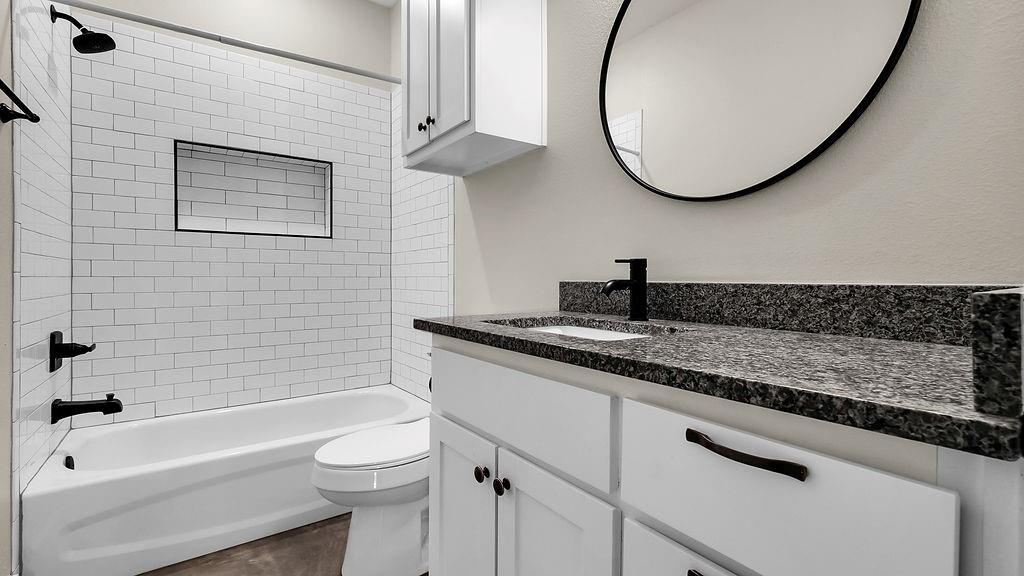727 East Gandy Street Denison, TX 75021 - Photo 7 of 21 a bathroom with a sink a toilet and a bathtub