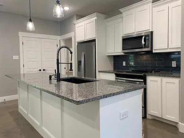 a kitchen with a sink a counter space and stainless steel appliances
