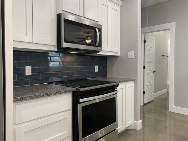 a kitchen with a sink and a stove with wooden floor