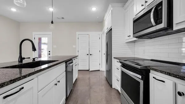 a kitchen with a sink stove and cabinets
