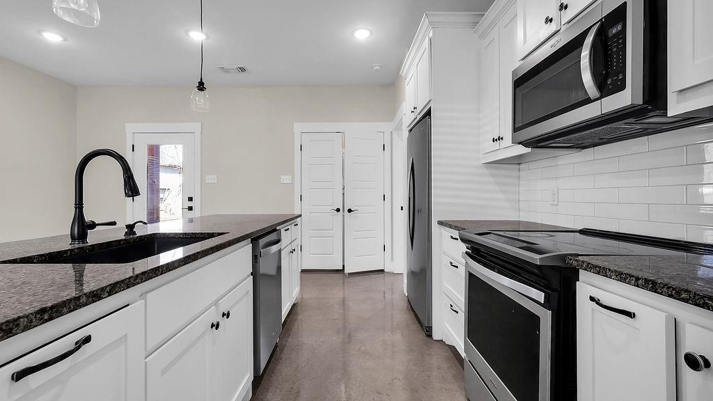 727 East Gandy Street Denison, TX 75021 - Photo 10 of 21 a kitchen with a sink stove and cabinets