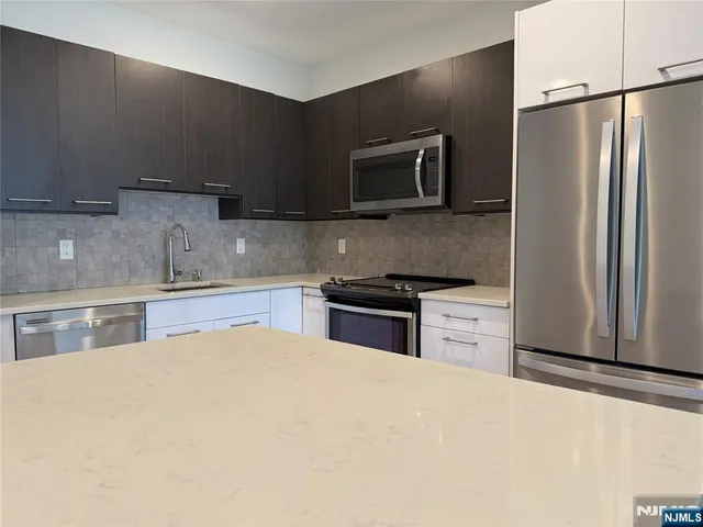 a kitchen with stainless steel appliances a refrigerator stove and microwave