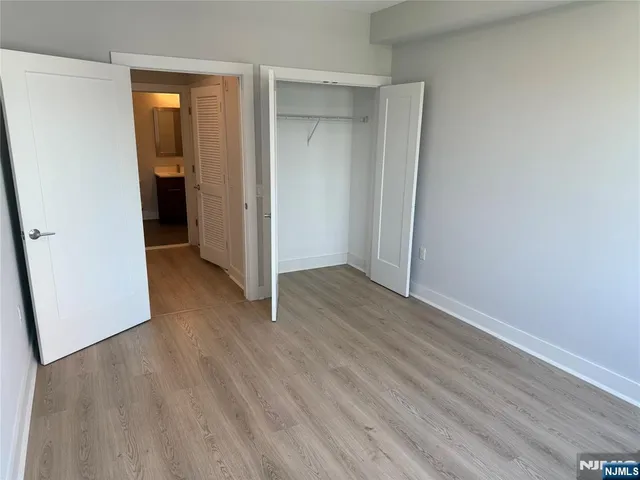 an empty room with wooden floor and closet