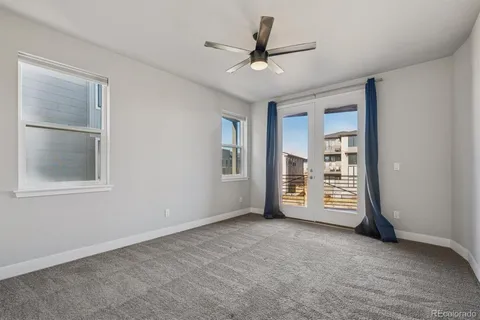 a view of an empty room with a ceiling fan and window