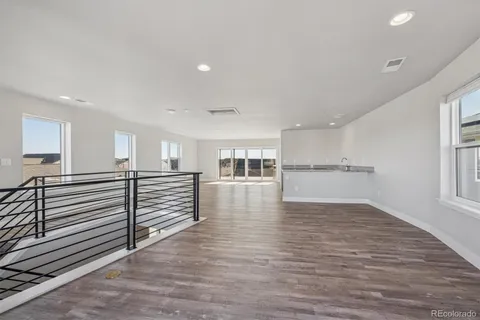 a view of a kitchen with wooden floor and a window