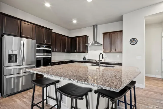 a kitchen with kitchen island granite countertop a wooden cabinets and stainless steel appliances