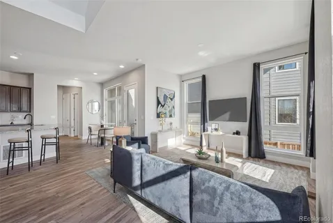 a living room with furniture wooden floor and a large window