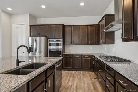 a kitchen with stainless steel appliances granite countertop a sink stove and refrigerator