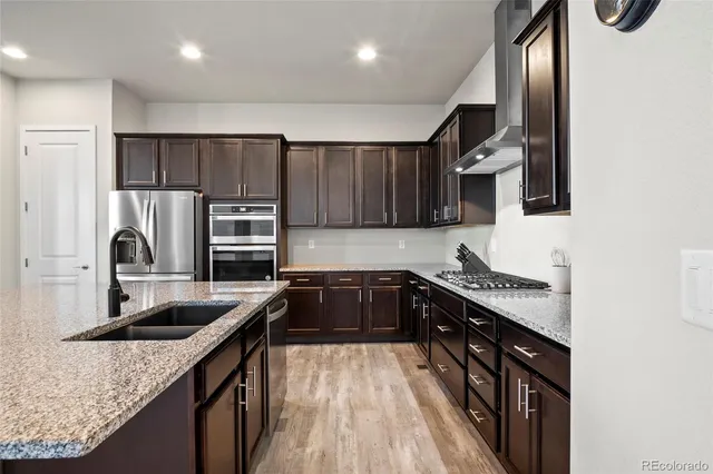 a kitchen with stainless steel appliances granite countertop a sink stove and refrigerator