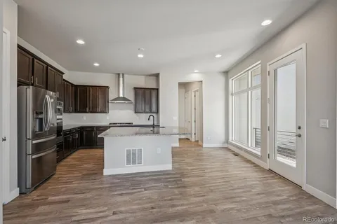 a large kitchen with stainless steel appliances granite countertop a stove a sink and a refrigerator