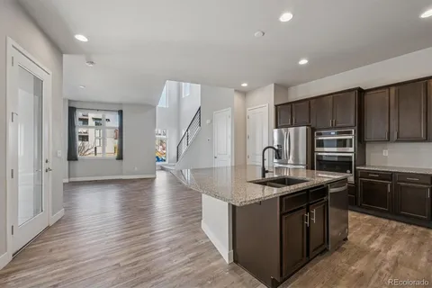 a kitchen that has a lot of cabinets in it and wooden floors