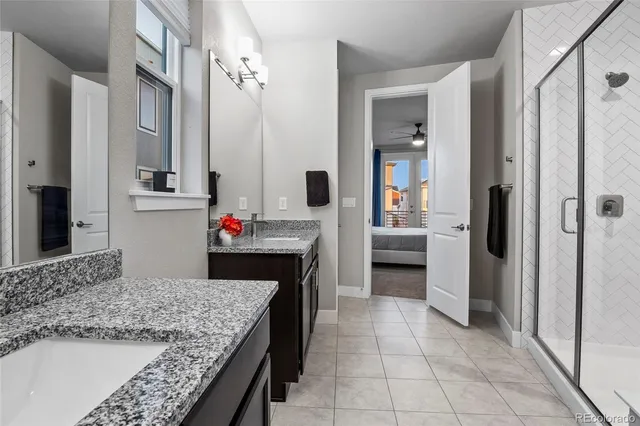 a en suite bathroom with a granite countertop sink and a mirror