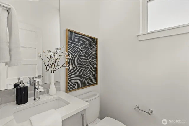 a bathroom with a sink a toilet and mirror