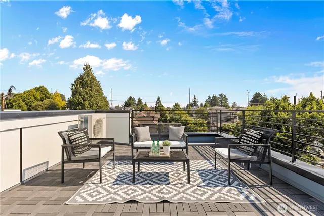 a roof deck with table and chairs