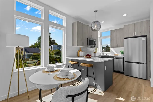 a kitchen with sink refrigerator dining table and chairs