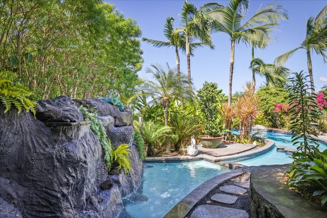 a view of a backyard with couches plants and large tree