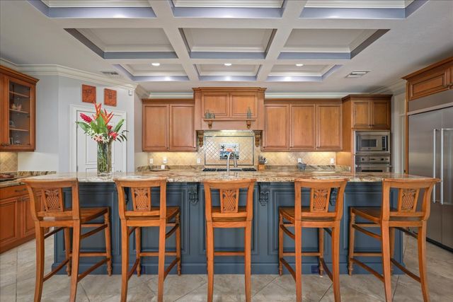 a kitchen with stainless steel appliances granite countertop a table chairs sink and cabinets