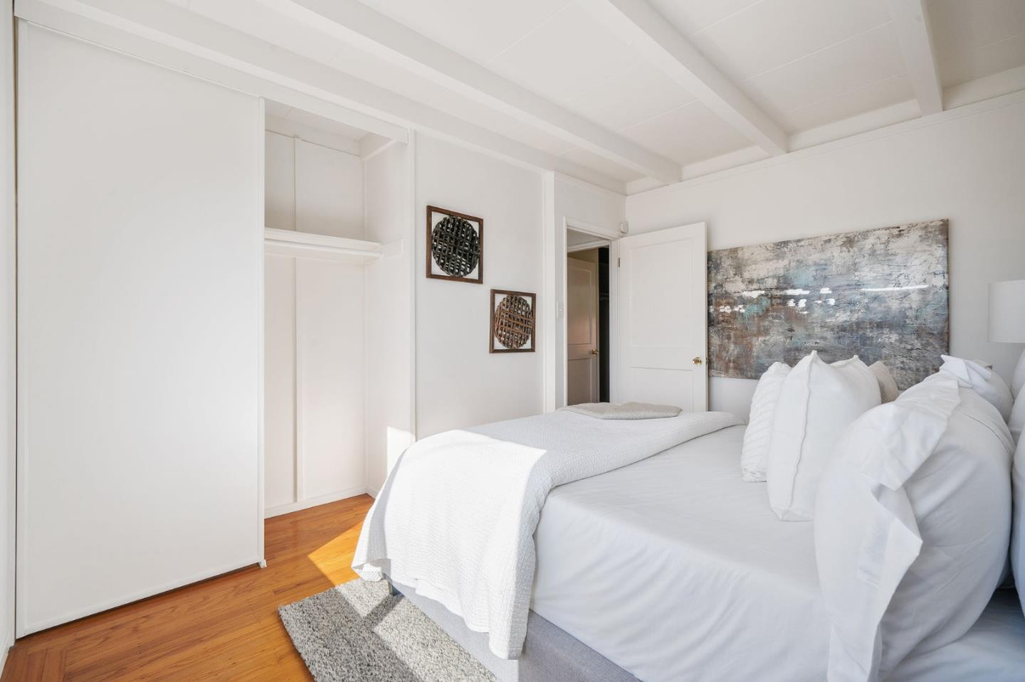 559 Manor Drive Pacifica, CA 94044 - Photo 23 of 38 a bedroom with a bed and wooden floor